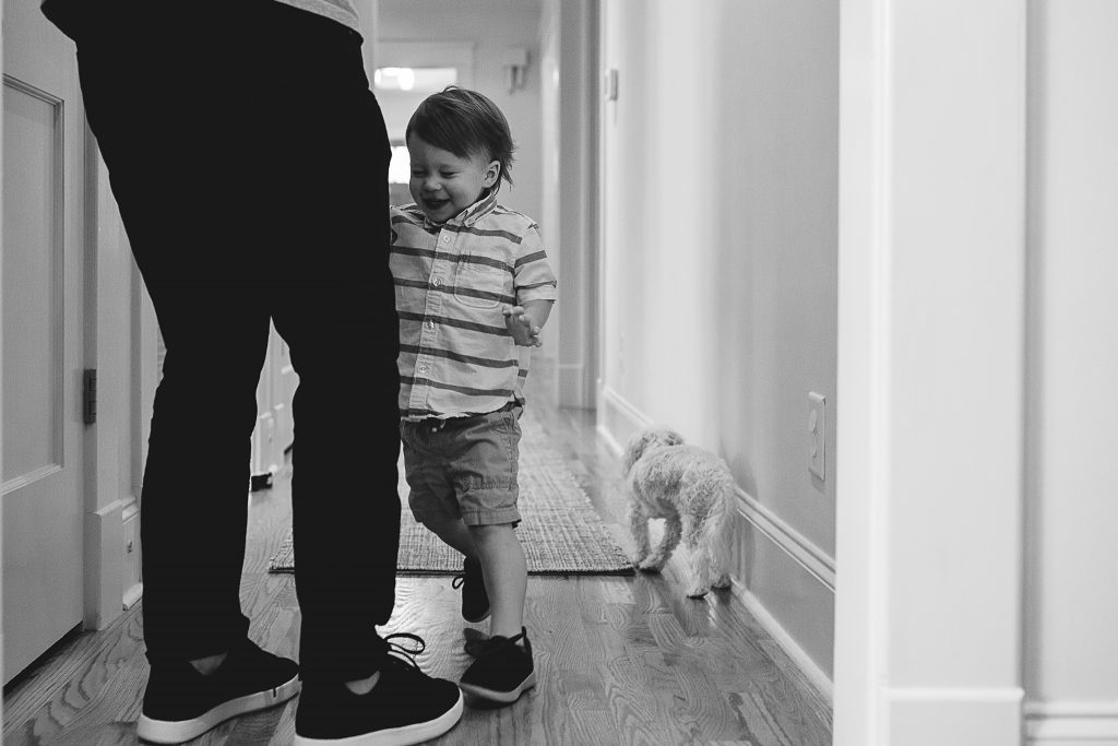 little boy playing with his dad at home