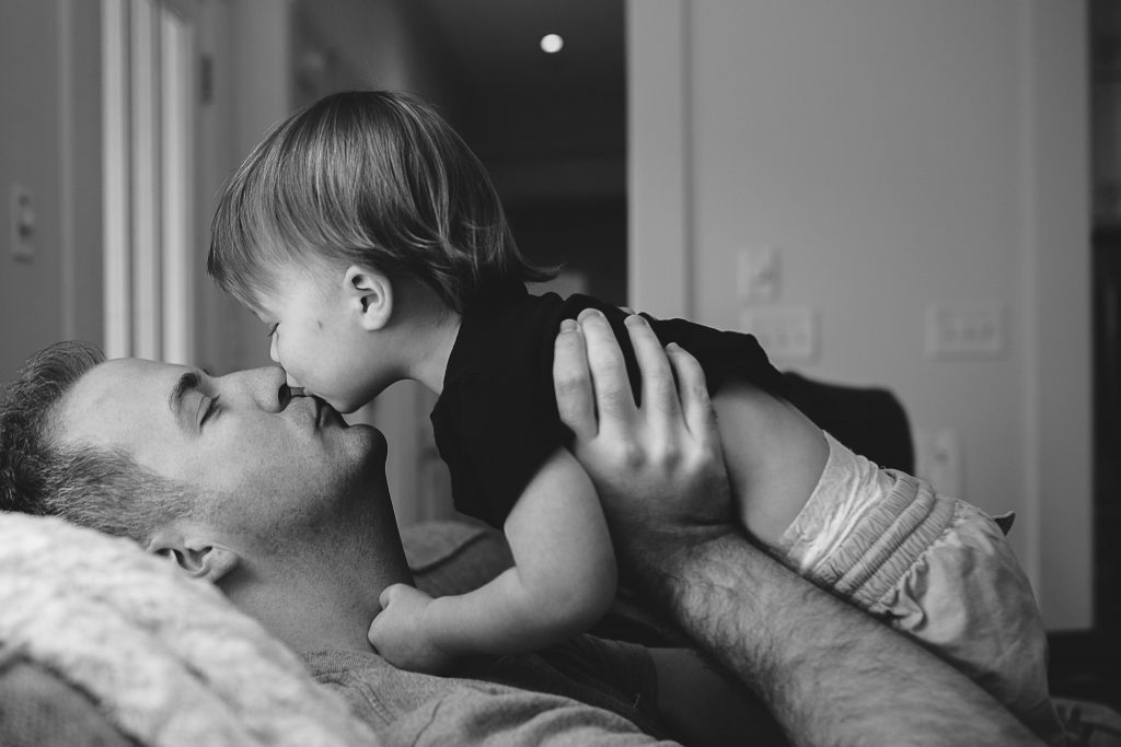 dad playing and kissing with his son