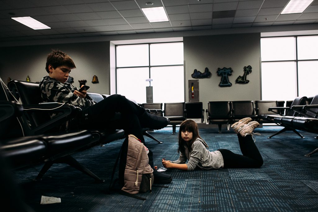 children waiting at the airport for a plane to leave