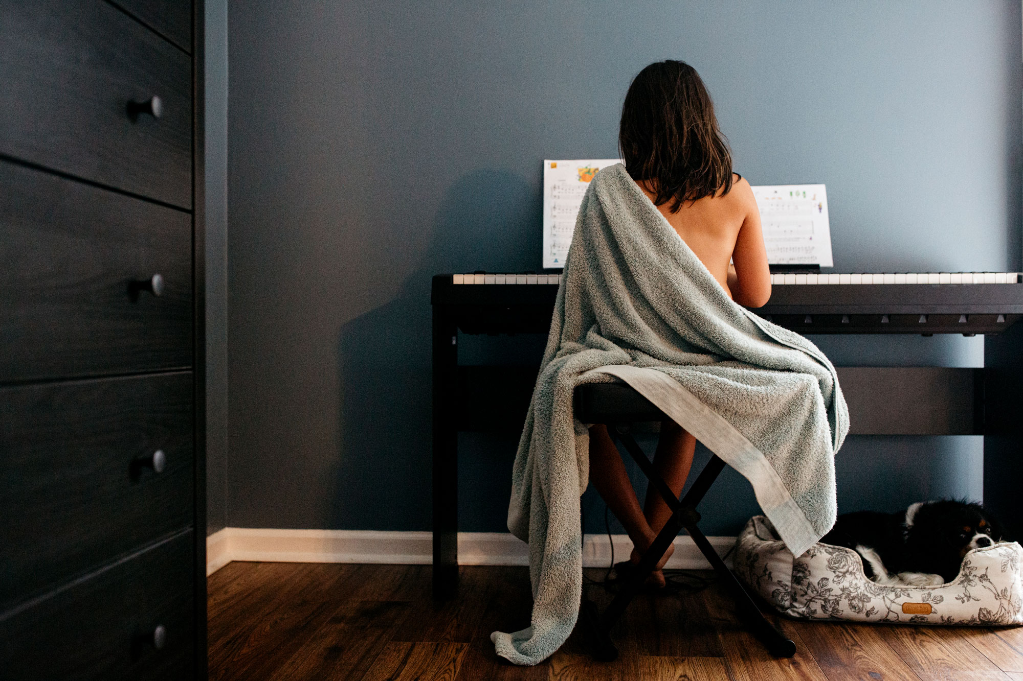 girl playing piano with a blu towel