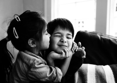 siblings kissing each other with caring