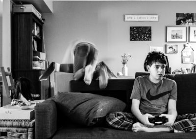 boy playing video games while sister is acting like crazy