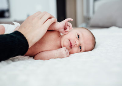 newborn candid photo with her mom's hand