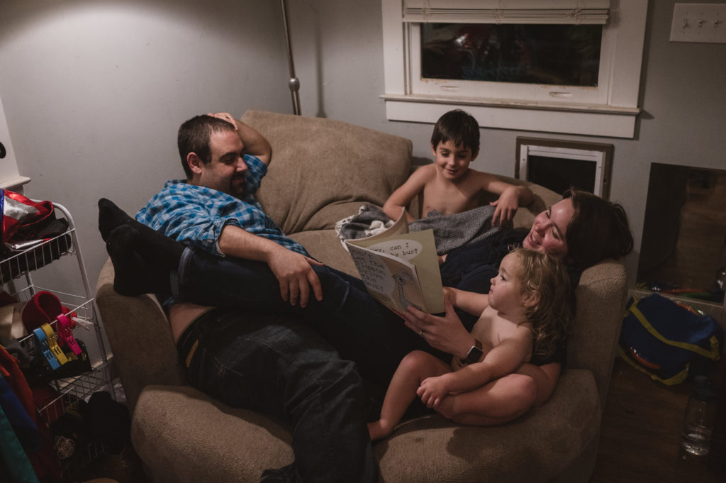 Family reading books on the couch