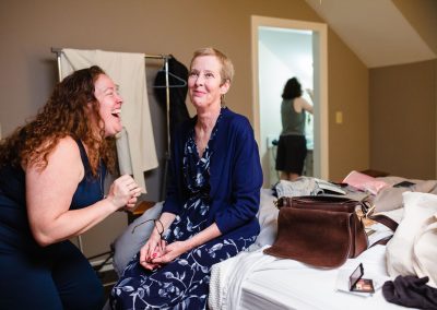 bride's sister doing make up to her mom and laughing