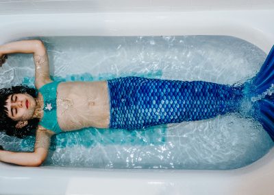 girl dressed up as a mermaid in the bath tub