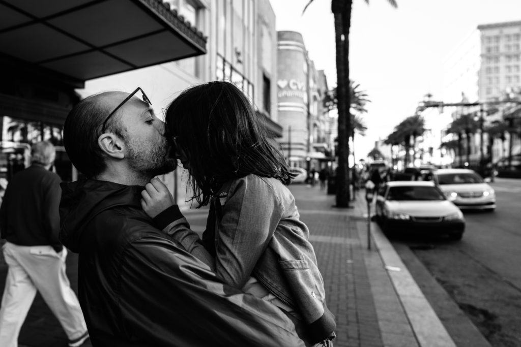 dad kissing his daughter in the street