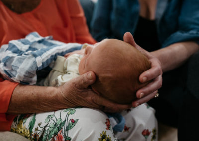 mom and grandma holding a newborn's head