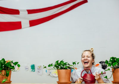 lady entrepreneur laughing in her community space with a Swedish flag