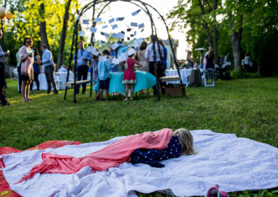 kid sleeping in the grass at a wedding reception