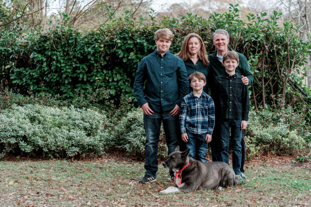 family of four with a dog posing for a portrait